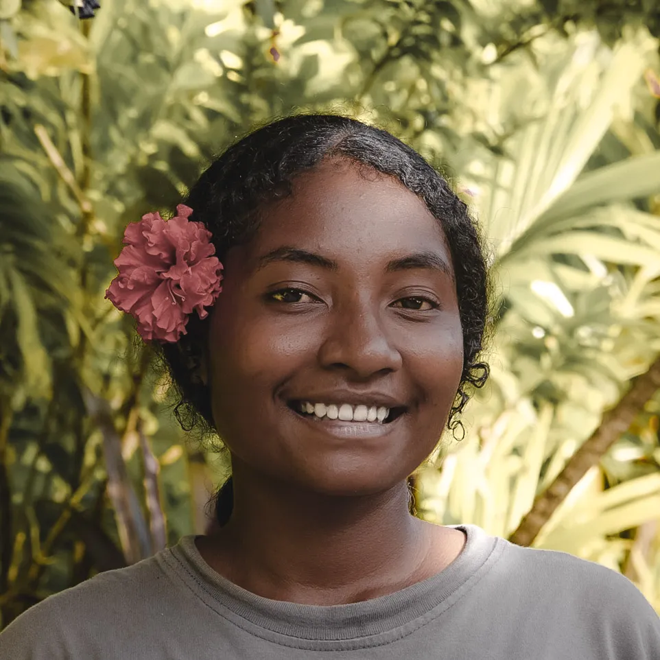 Portrait of Yudris, a member of our local guide team, smiling with a pink hibiscus flower in her hair